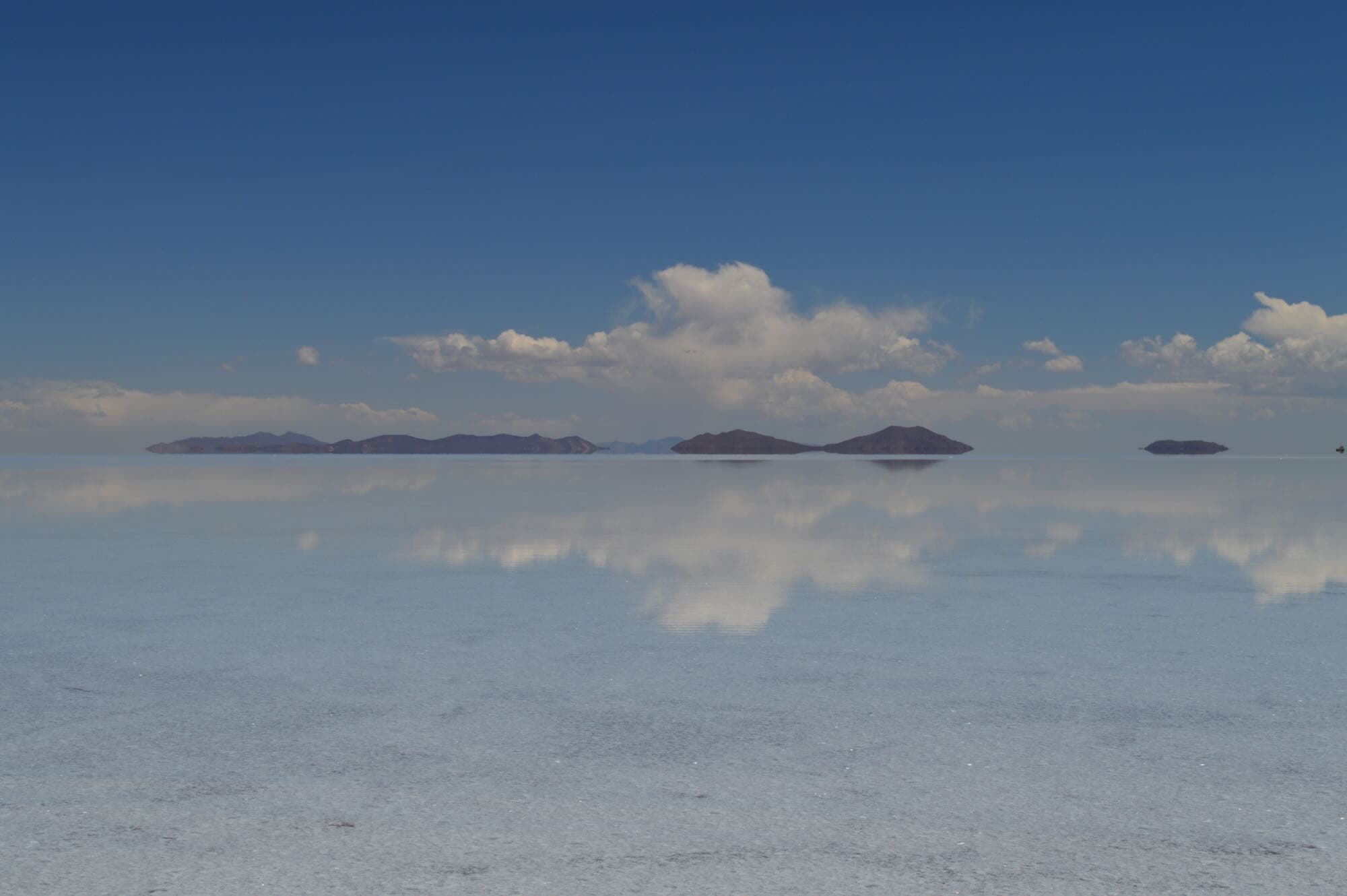 Photo by Lucas Homer Hero image - Thin layer of water creates a glass mirror effect over the expansive Uyuni salt flats, Bolivia